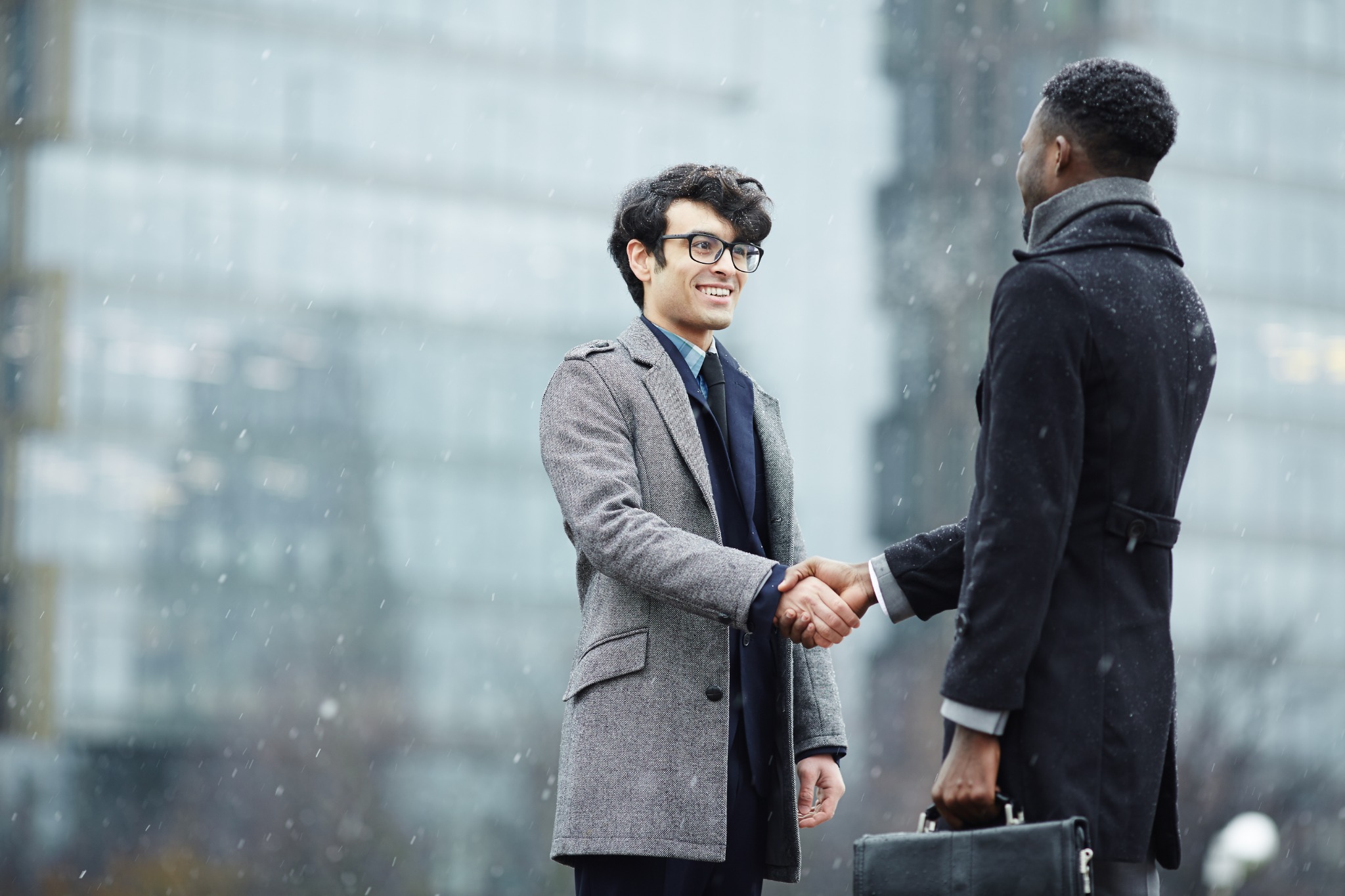 Two leaders shaking hands outside an office building